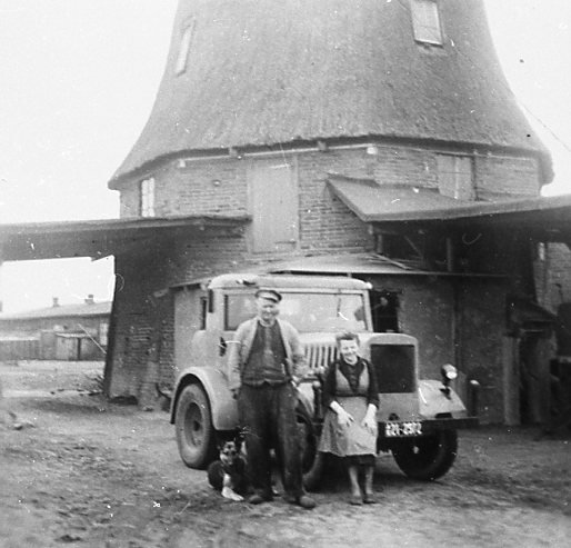 Mühle mit Zugmaschine, davor Müller Hinrichs und Ehefrau Minna mit Schäferhund