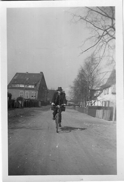 Pastor Nay auf Fahrrad in höhe der Friedhofskapelle